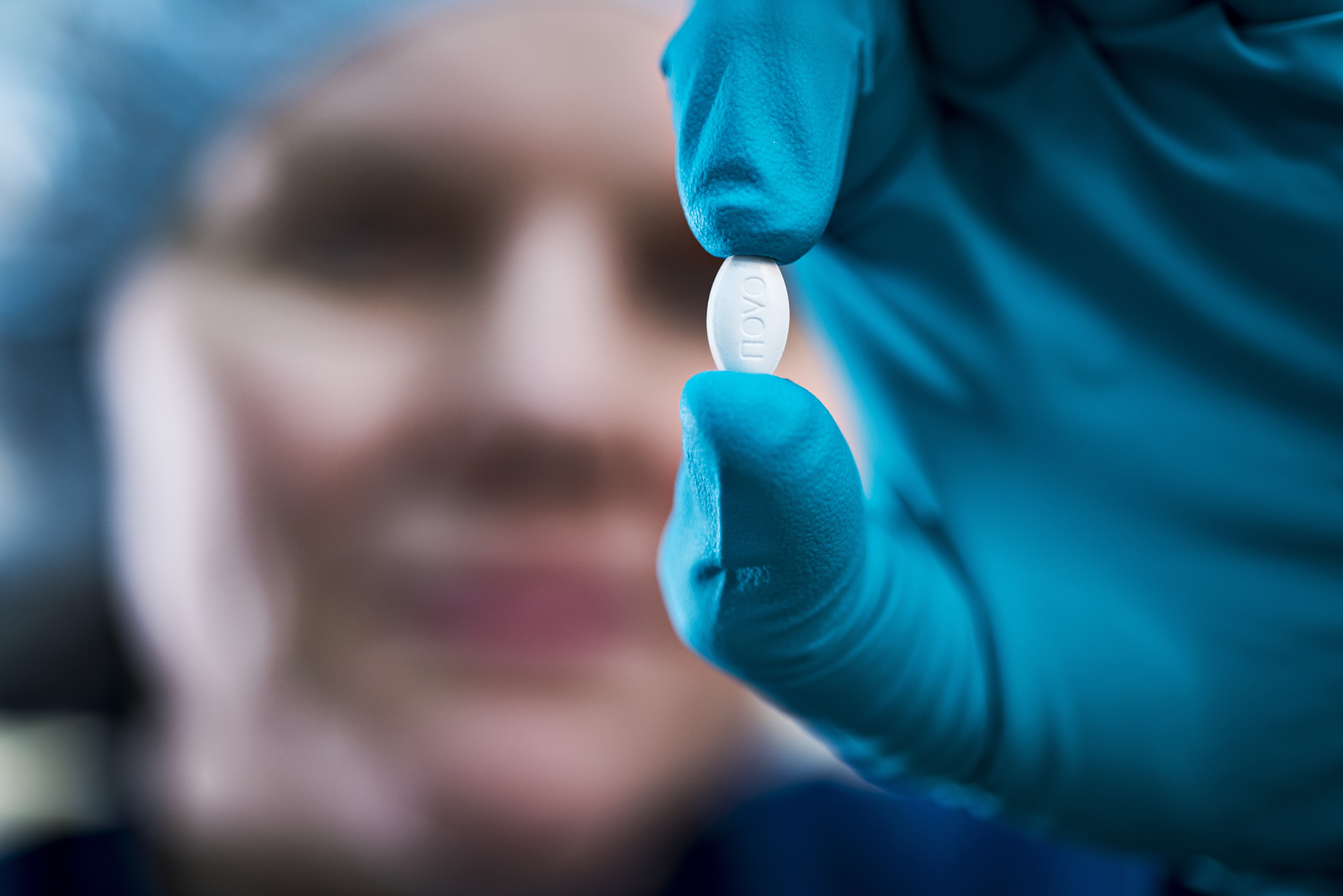 Our scientific approach, Novo Nordisk employee holding a pill.